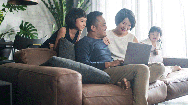 asian family using a laptop in their living room